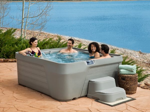 Friends in a Freeflow portable hot tub lakeside